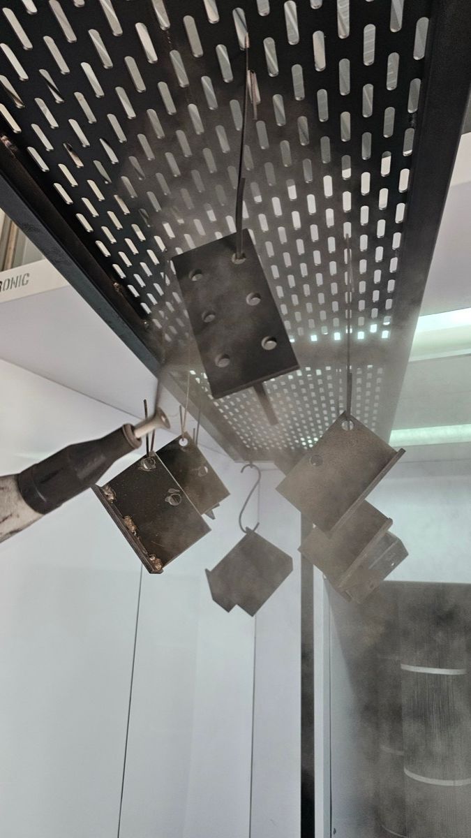 Marco de acero recién pintado dentro de la cabina de pintura electrostática de TESEY
